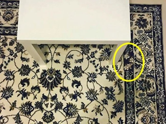 Điện thoại nằm ở chân bàn bên phải.